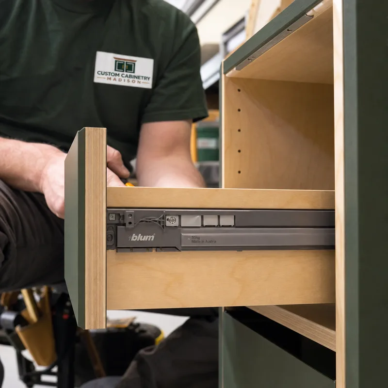 Close-up of soft-close drawer hardware and clean edge banding on a closet cabinet drawer front